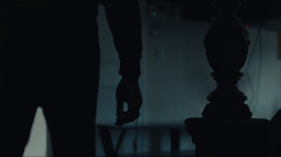 a person standing next to a chair in a dark room