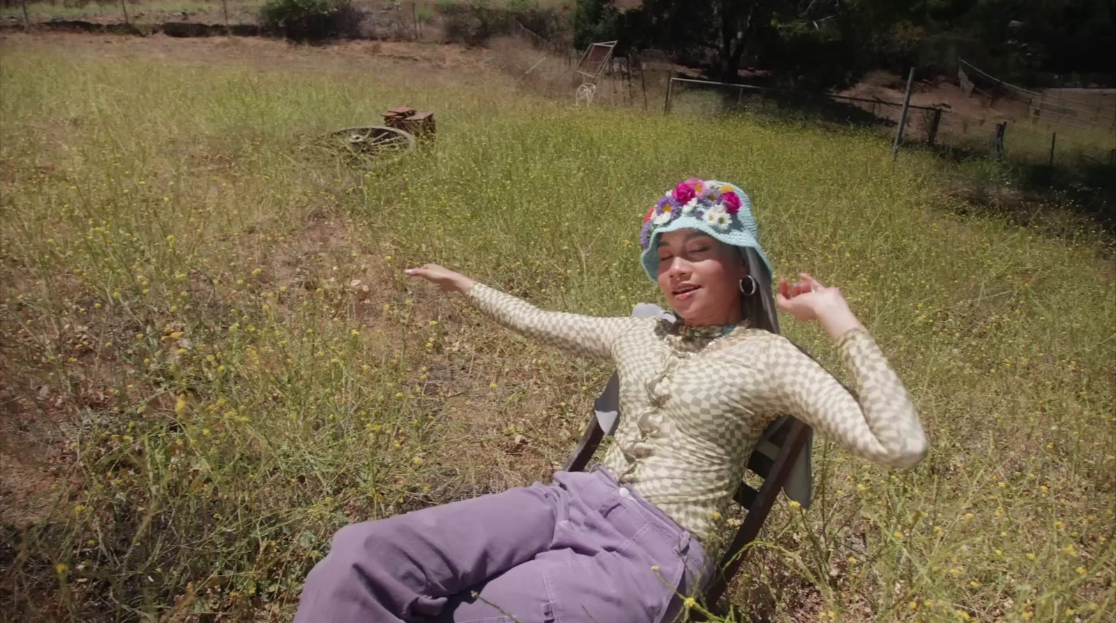 a woman sitting in a chair in a field