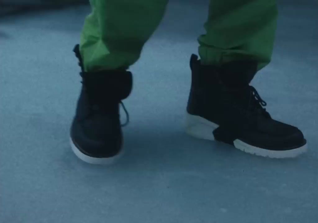 a person wearing black shoes and green pants