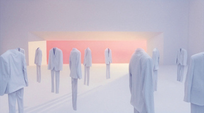 a group of people standing in front of a white room