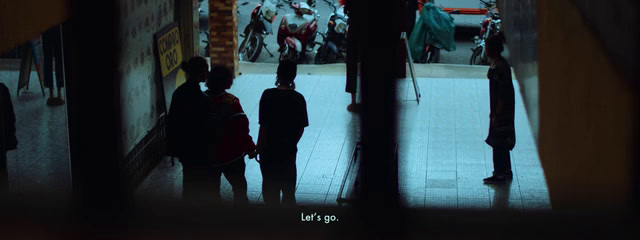 a group of people walking down a street at night