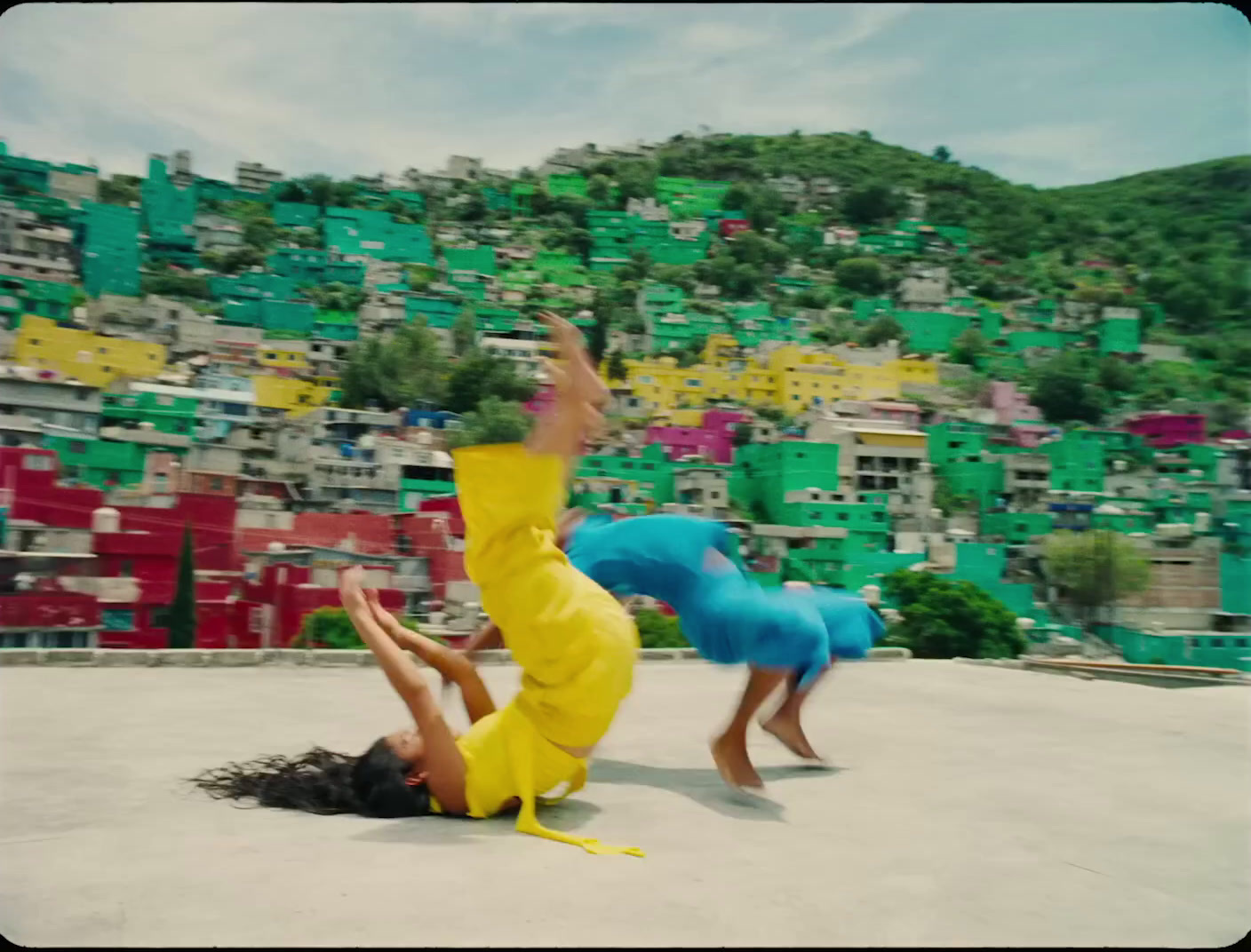 two people doing a handstand in front of a mountain