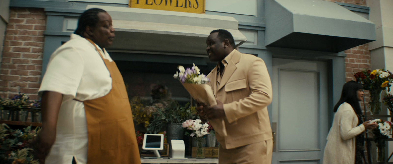 a couple of men standing next to each other in front of a building