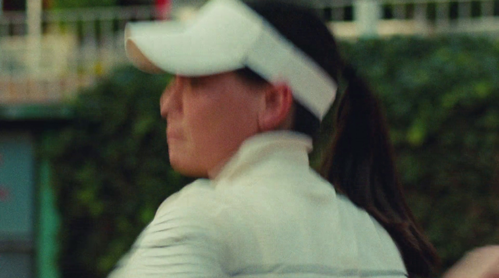 a woman in a white uniform holding a tennis racquet