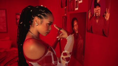 a woman in a red room pointing at pictures on the wall