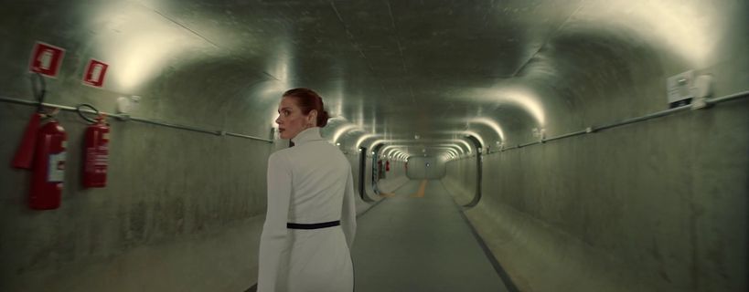 a woman in a white dress is standing in a tunnel