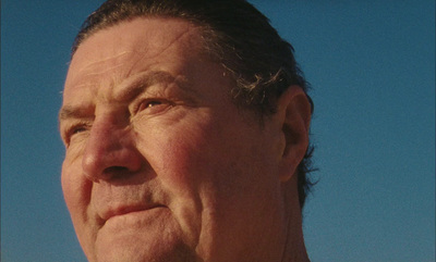 a close up of a person wearing a suit and tie