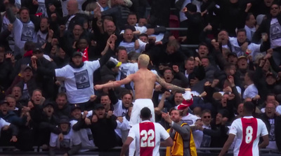 a shirtless man standing in front of a crowd of people