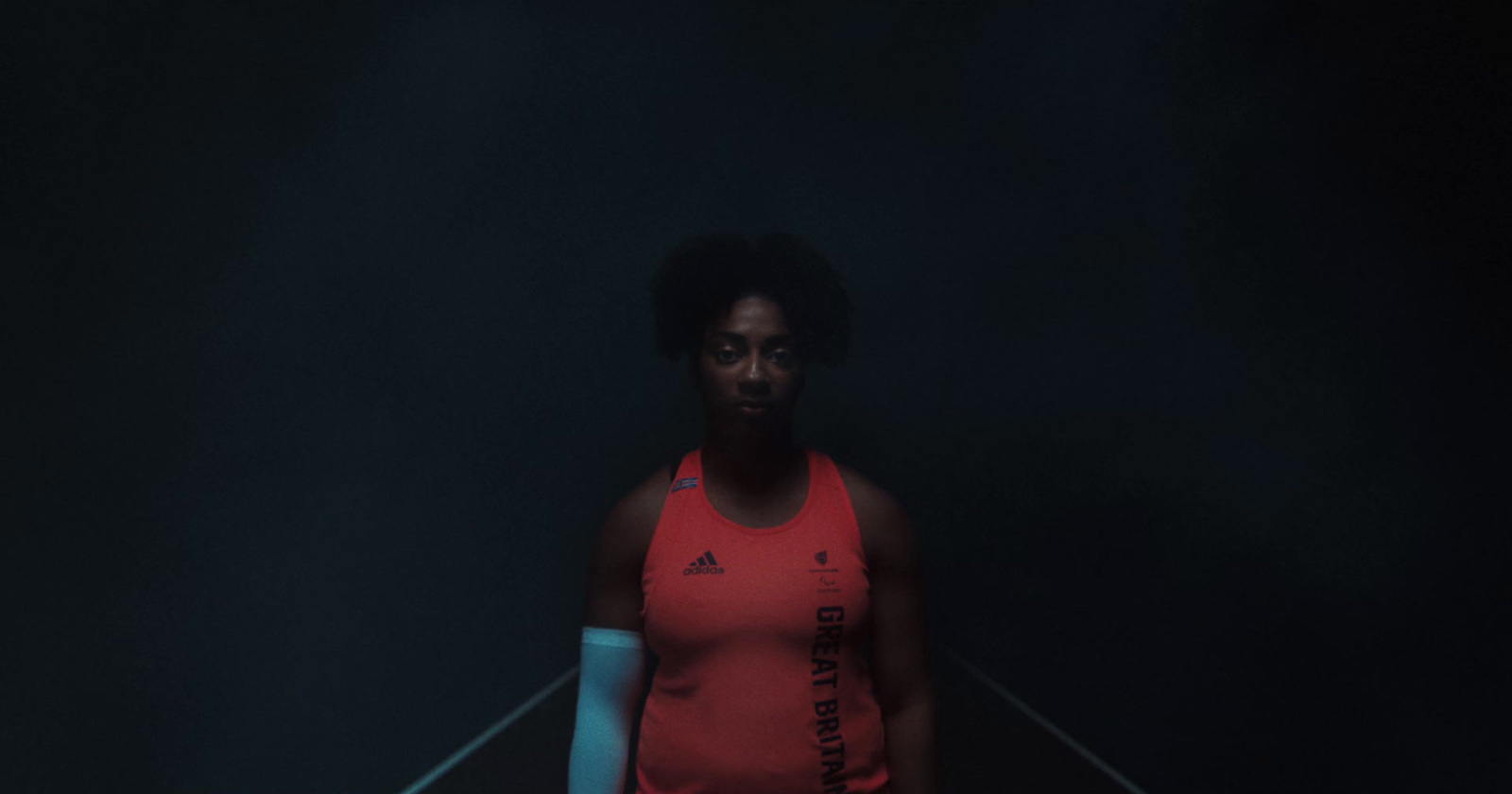 a woman holding a tennis racquet in a dark room