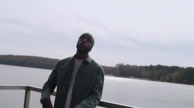 a man standing on a deck near a body of water