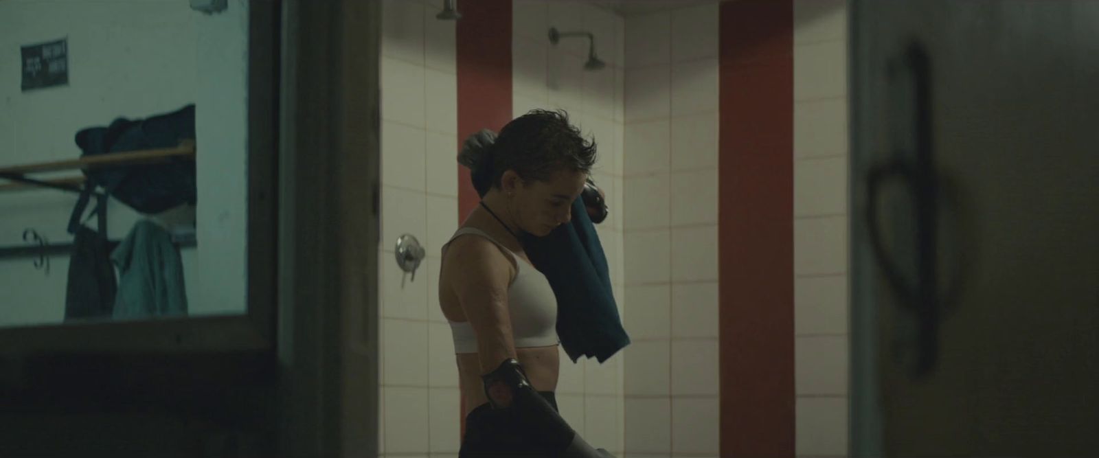 a woman standing in a bathroom holding a towel