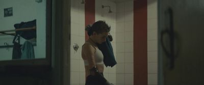 a woman standing in a bathroom holding a towel