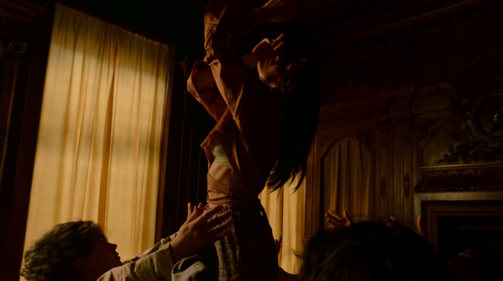 a woman standing on top of another woman in a room