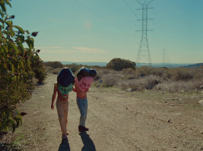 a couple of kids walking down a dirt road