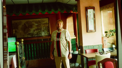 a man standing in a restaurant with a tie around his neck