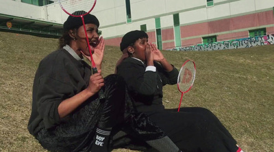 a couple of people sitting on the ground holding tennis racquets