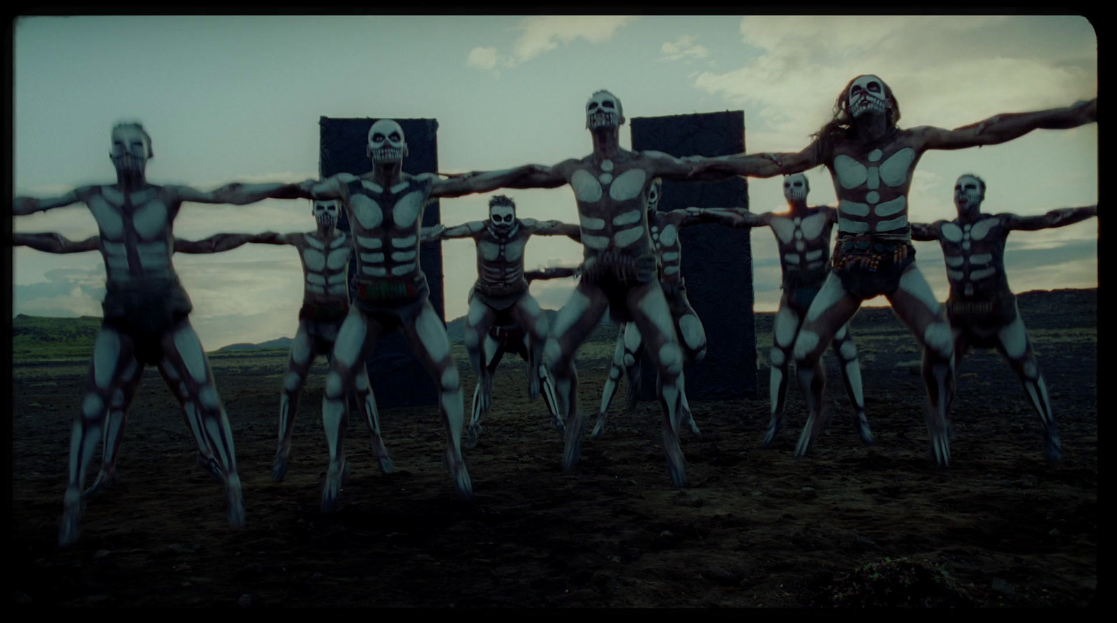 a group of skeletons standing in front of a cross