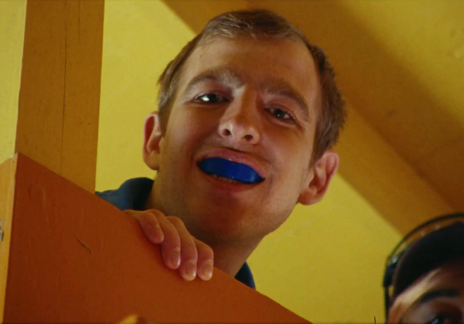 a man with a blue toothbrush in his mouth