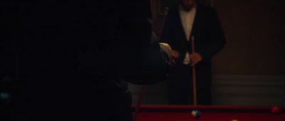 a man playing pool in a dark room