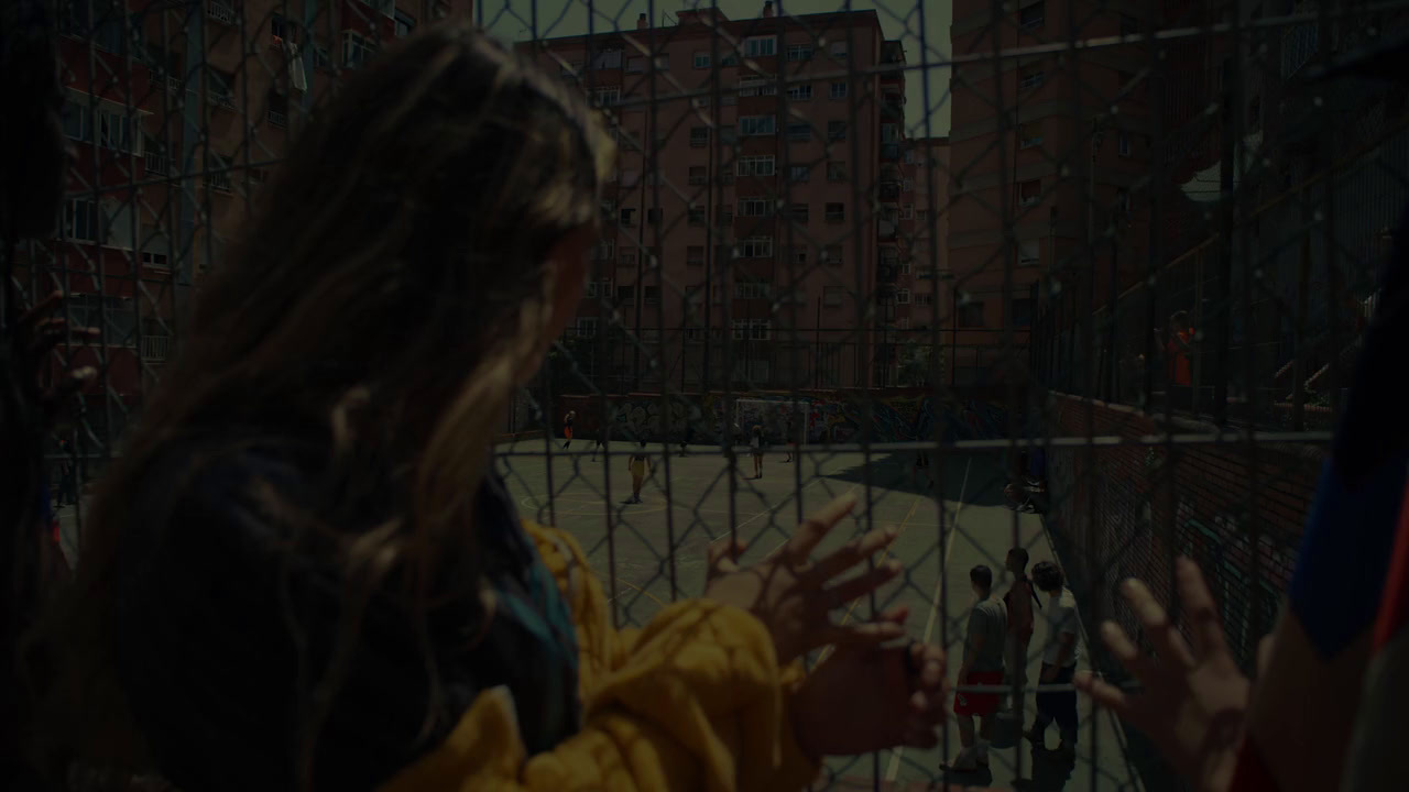 a group of people standing in front of a fence