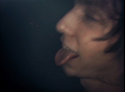 a person sticking their tongue out in the dark