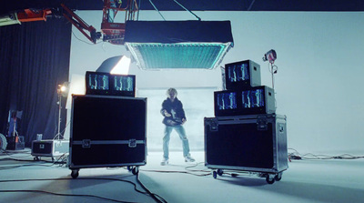 a man standing in front of a set of speakers