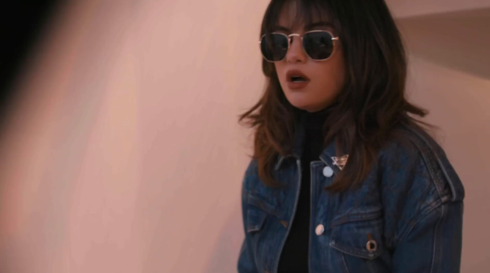 a woman wearing sunglasses and a denim jacket