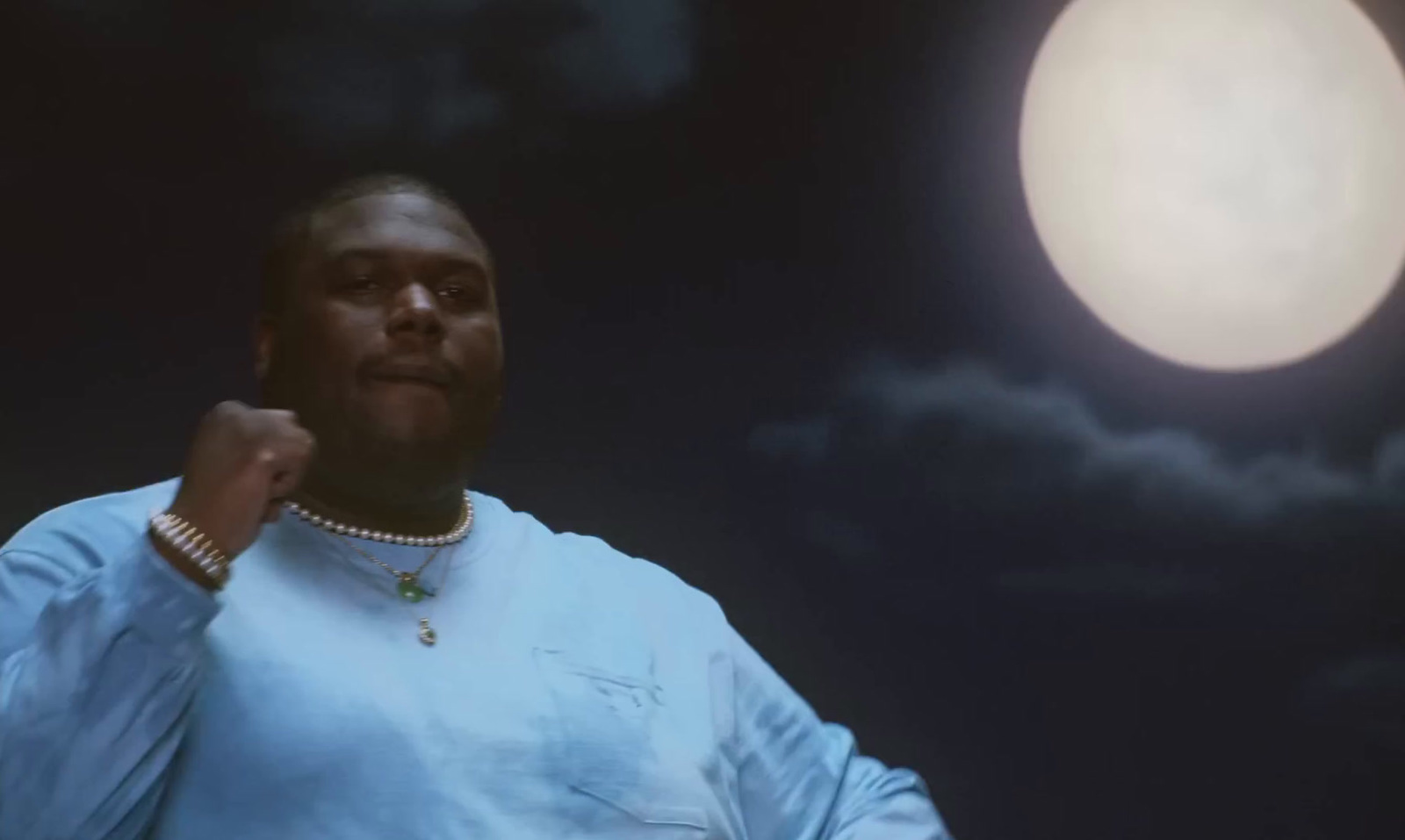 a man standing in front of a full moon