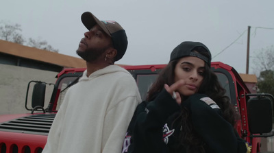 a man and a woman standing next to a red truck