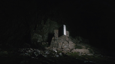 a window in the side of a mountain in the dark