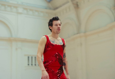 a man in a red dress holding a white frisbee