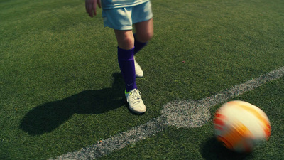 a soccer player kicking a soccer ball on a field