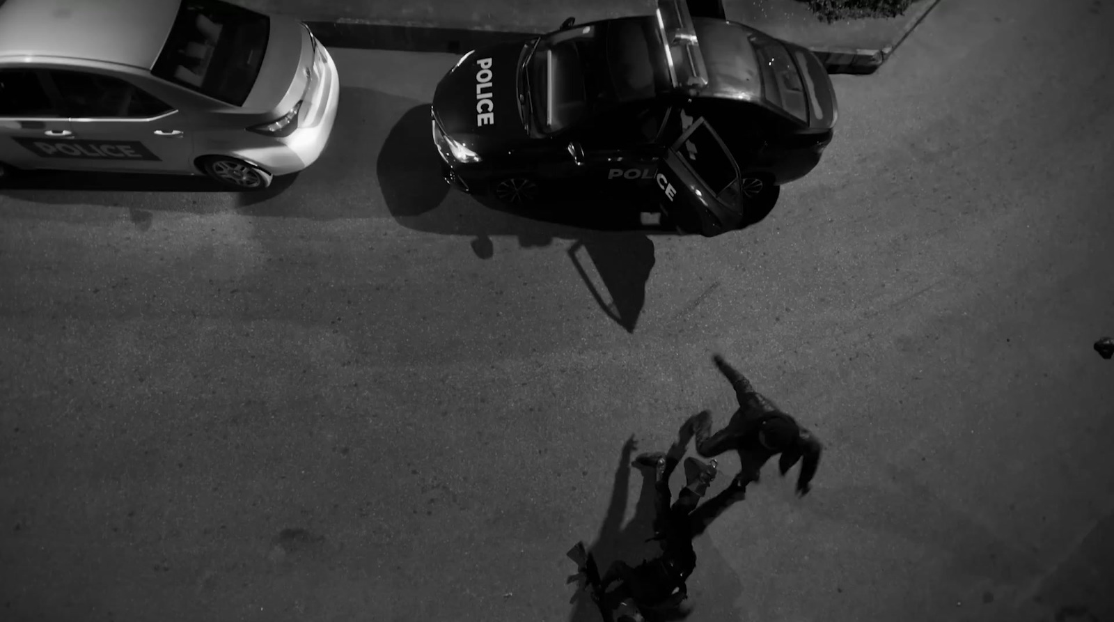 a black and white photo of two police cars