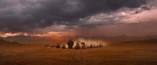 a group of people standing in the middle of a desert