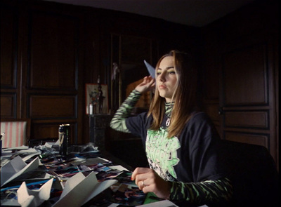 a woman sitting at a desk with a pair of scissors in her hand