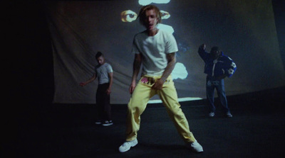 a man in yellow pants standing in front of a screen