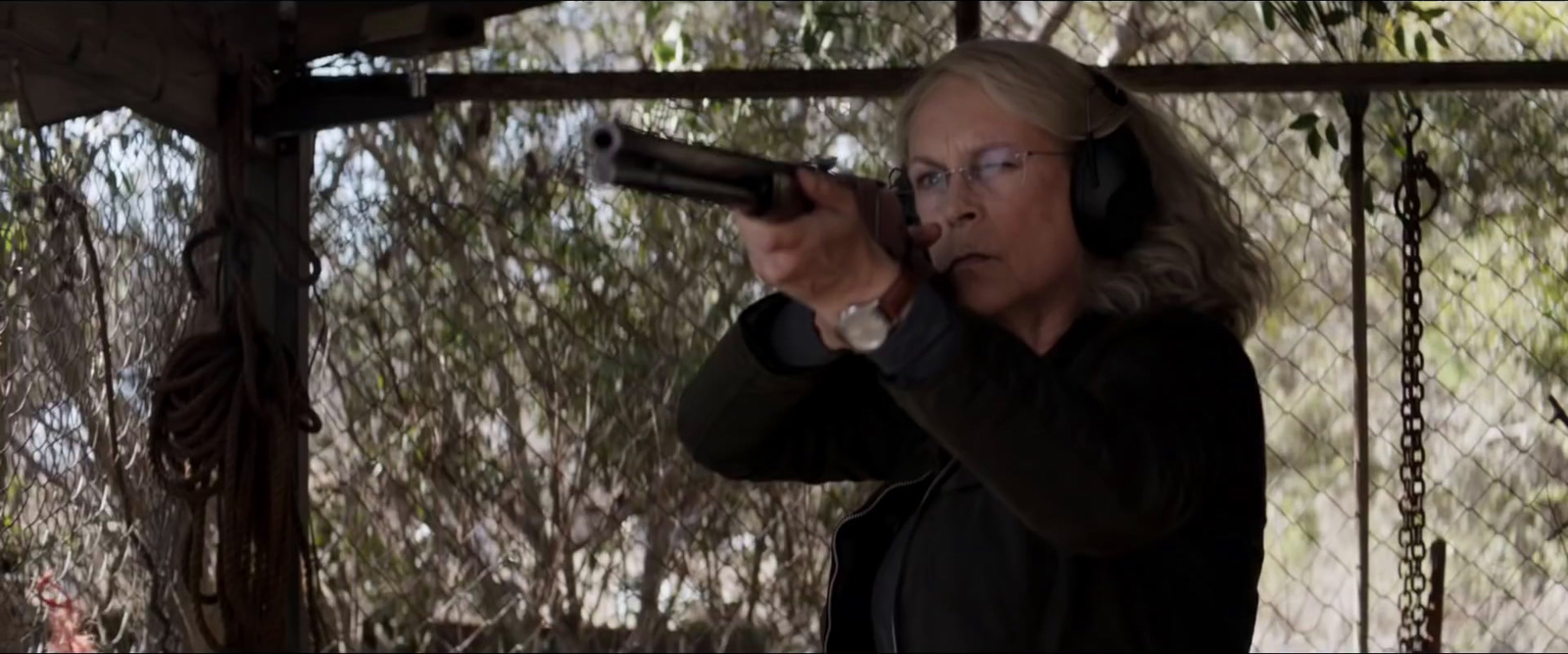 a woman holding a gun and wearing headphones