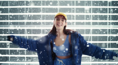 a woman standing in front of a window covered in snow