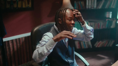 a man sitting in a chair talking on a cell phone