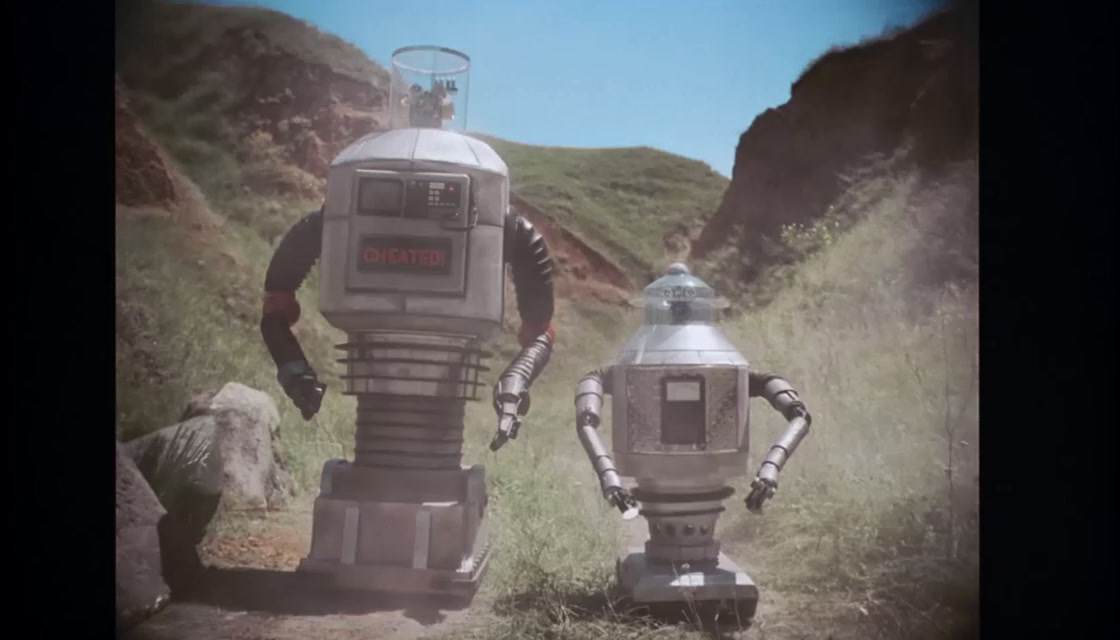 a couple of robots that are standing in the grass