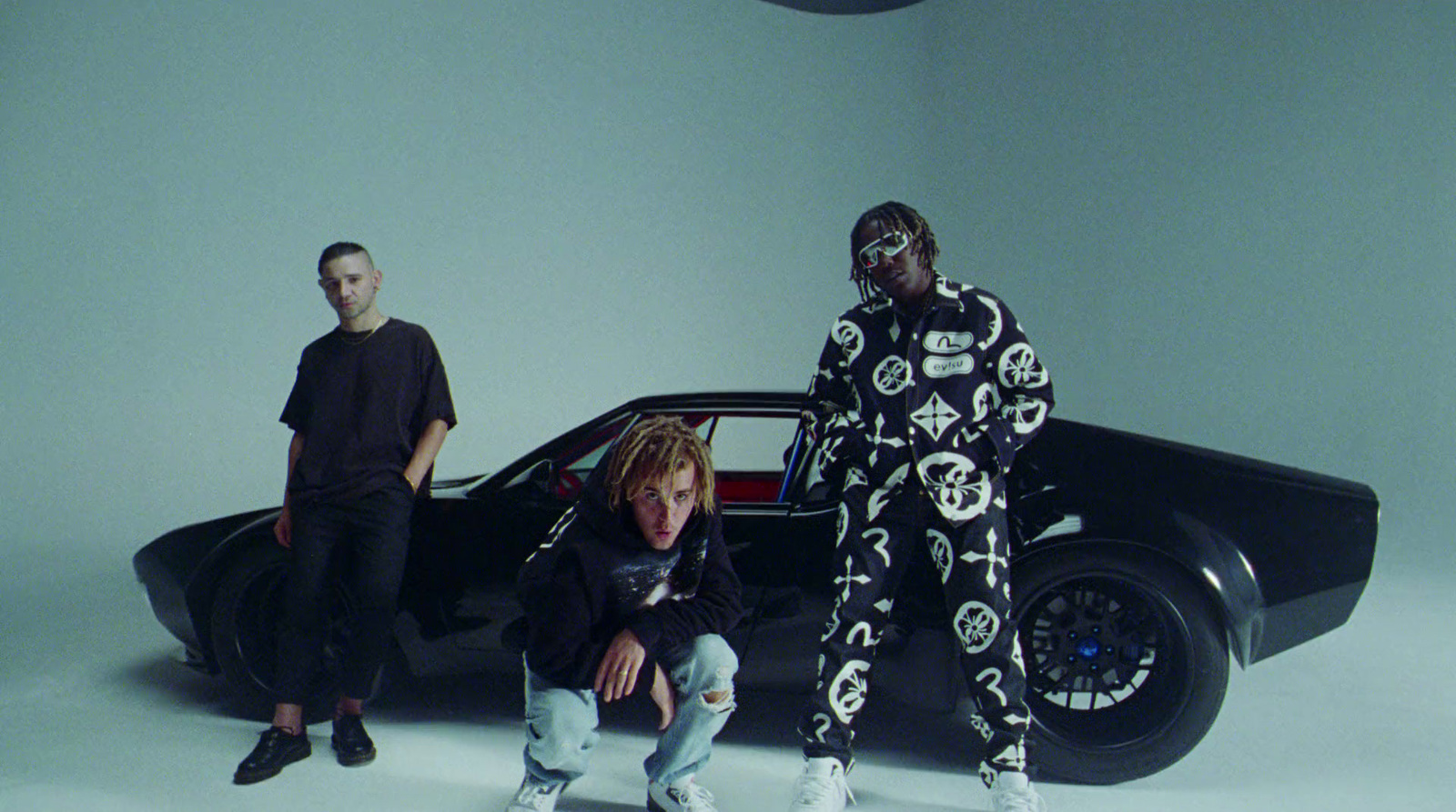 a group of people standing in front of a car