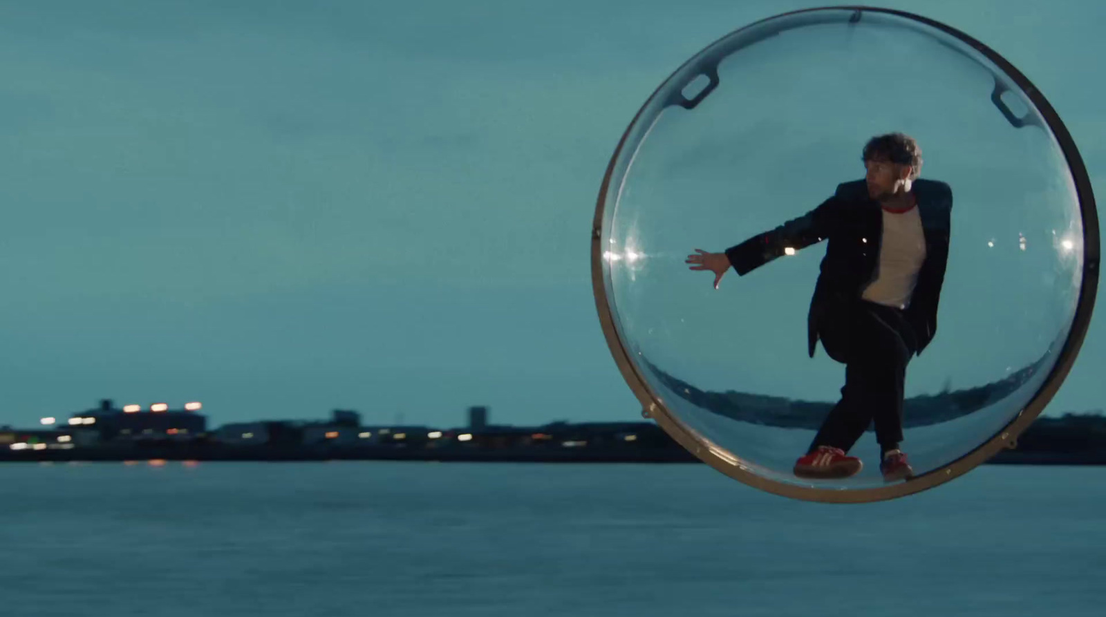 a man in a suit is standing inside a glass ball