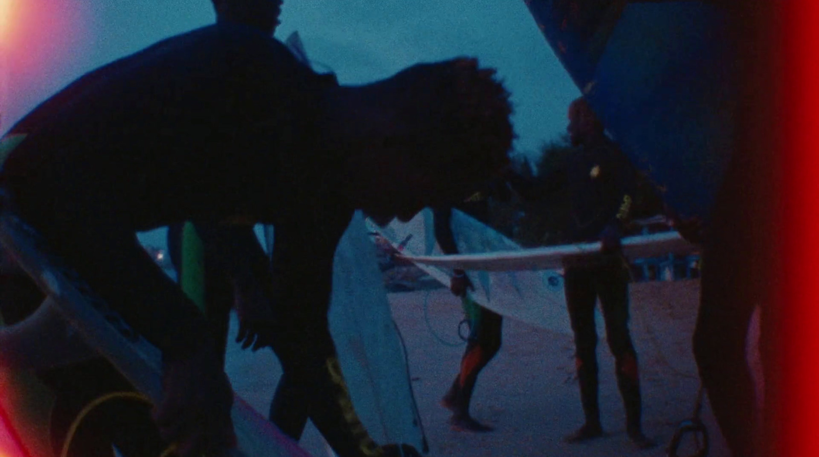 a man holding a surfboard while standing next to another man