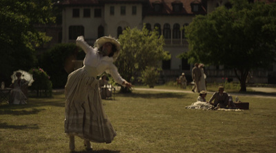 a woman in a dress is throwing a frisbee