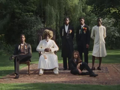 a group of people standing and sitting in a park