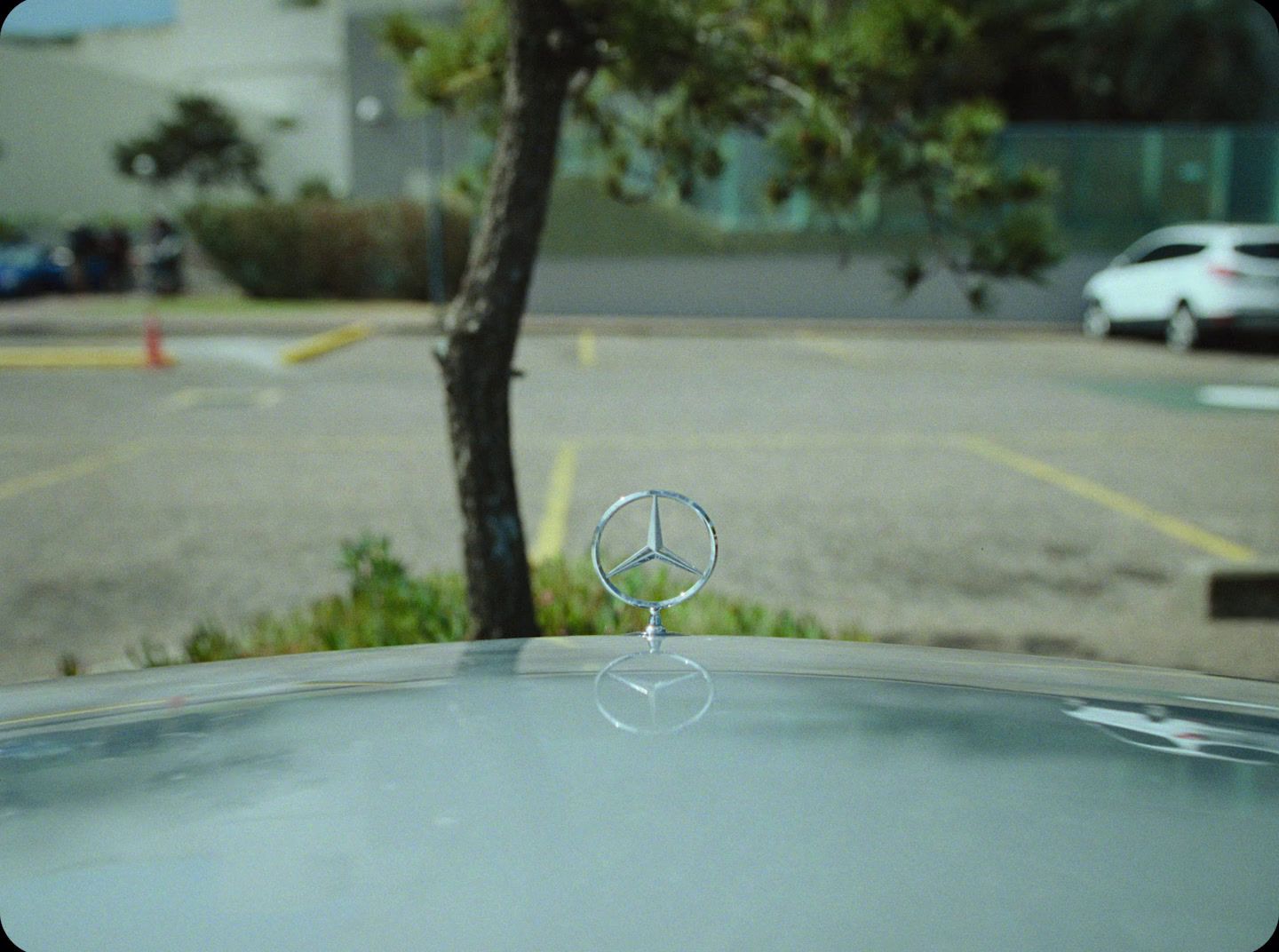 the hood ornament of a car parked in a parking lot