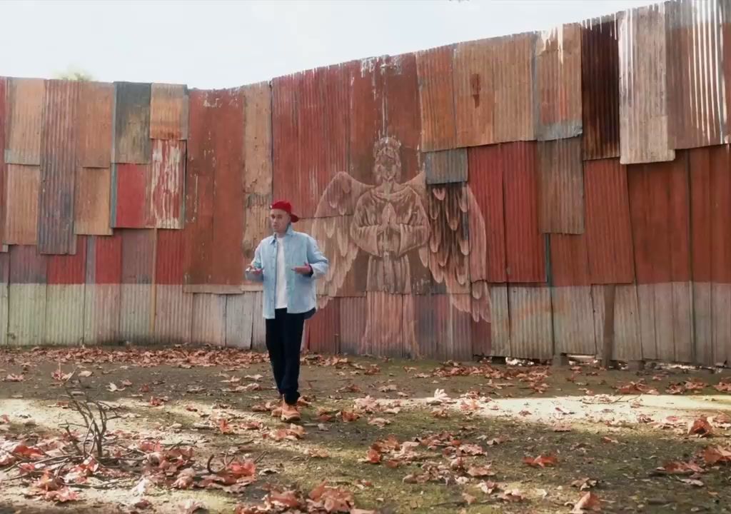 a man standing in front of a wooden wall