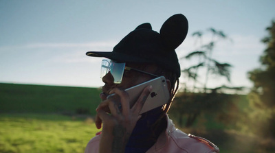 a man wearing a mickey ears hat talking on a cell phone