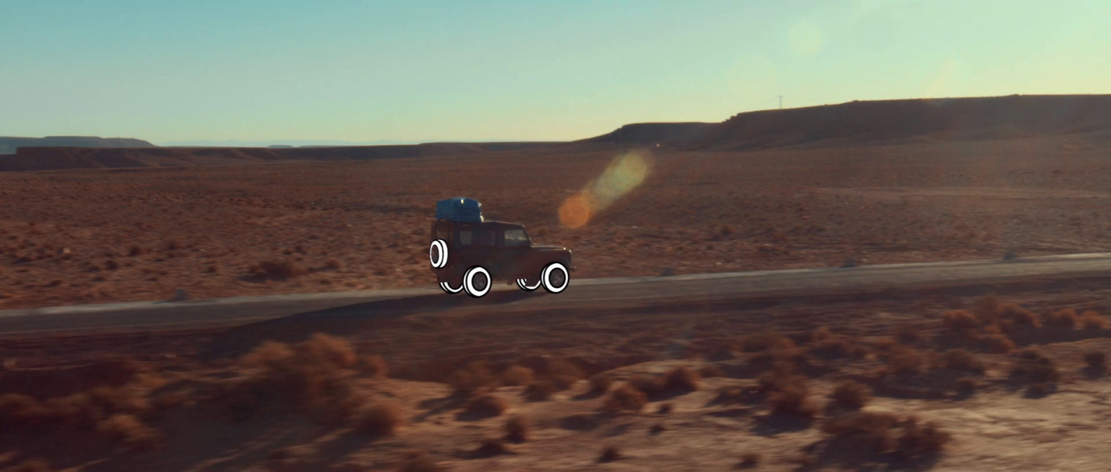 a truck driving down a road in the middle of the desert