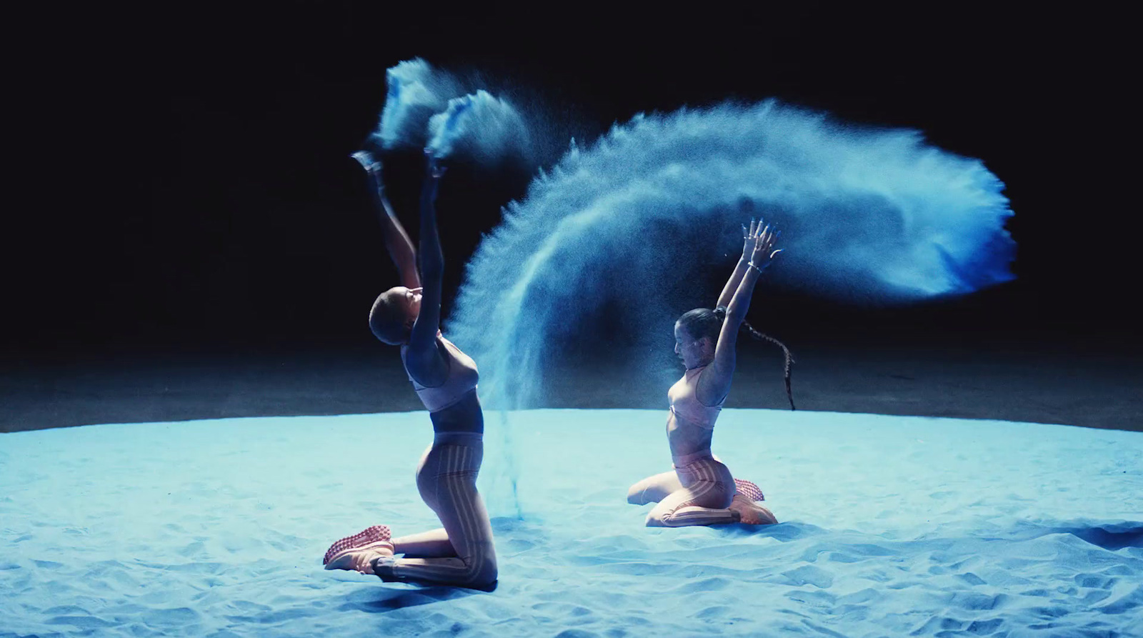 a couple of women sitting on top of a blue blanket